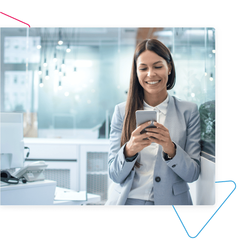 A woman smiling at her smartphone.