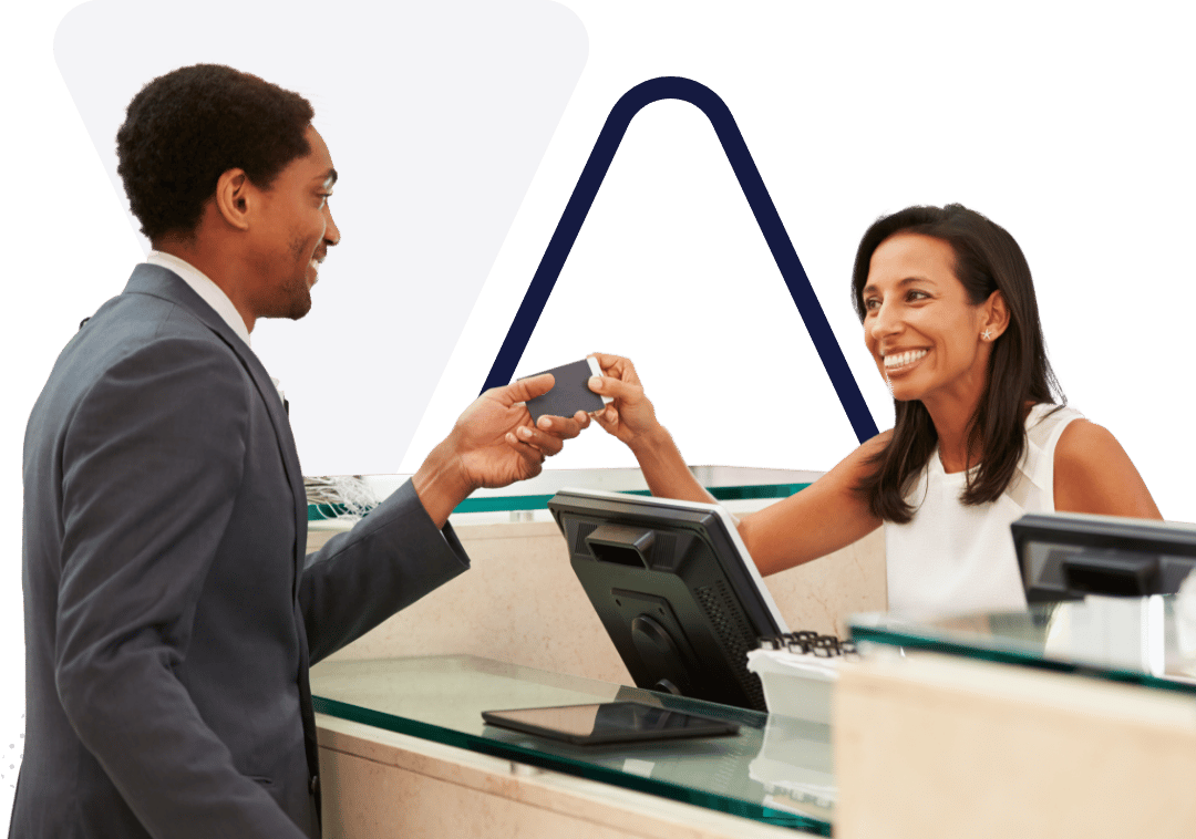 Man Paying For His Room At The Hotel Reception Desk