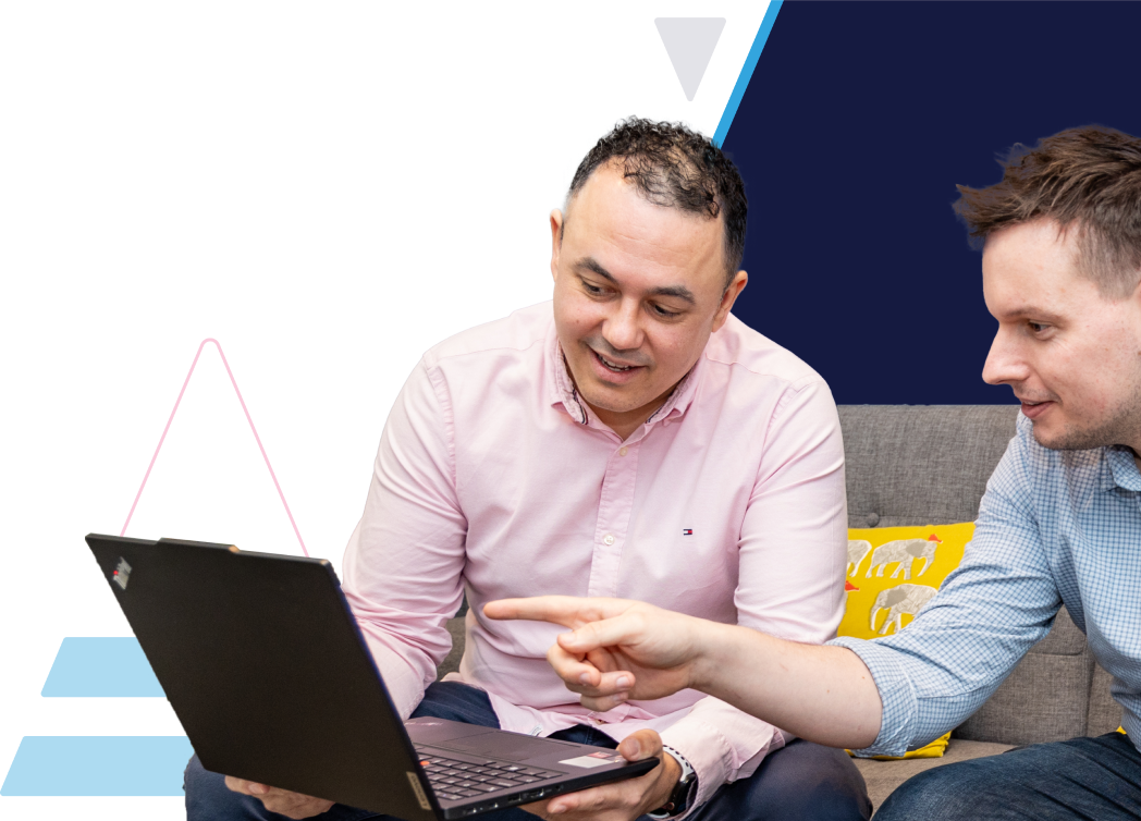 ITVET employees looking at laptop and pointing at the screen