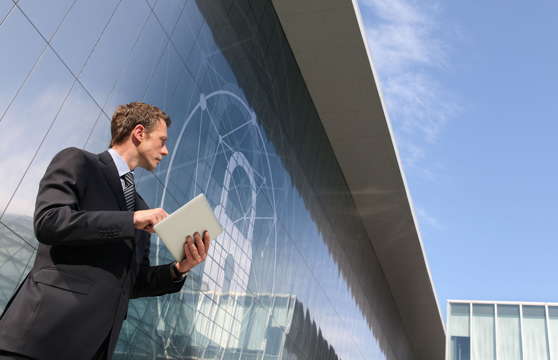 A man outside a building using a tablet.